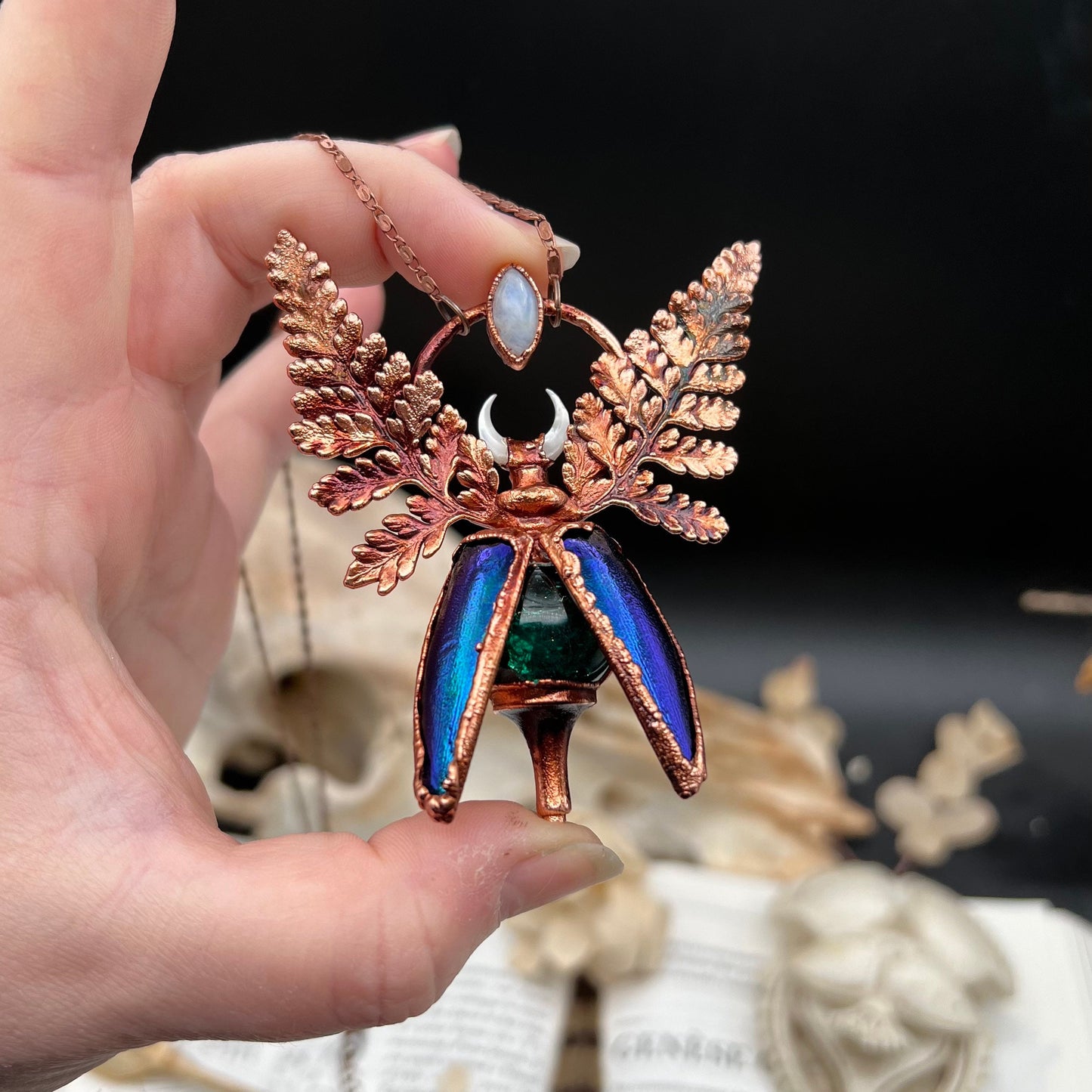 Chimera vial necklace with glittery green water, Copper eformed real beetle elytras with ferns wings, a rainbow moonstone and a white moon