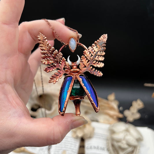 Chimera vial necklace with glittery green water, Copper eformed real beetle elytras with ferns wings, a rainbow moonstone and a white moon
